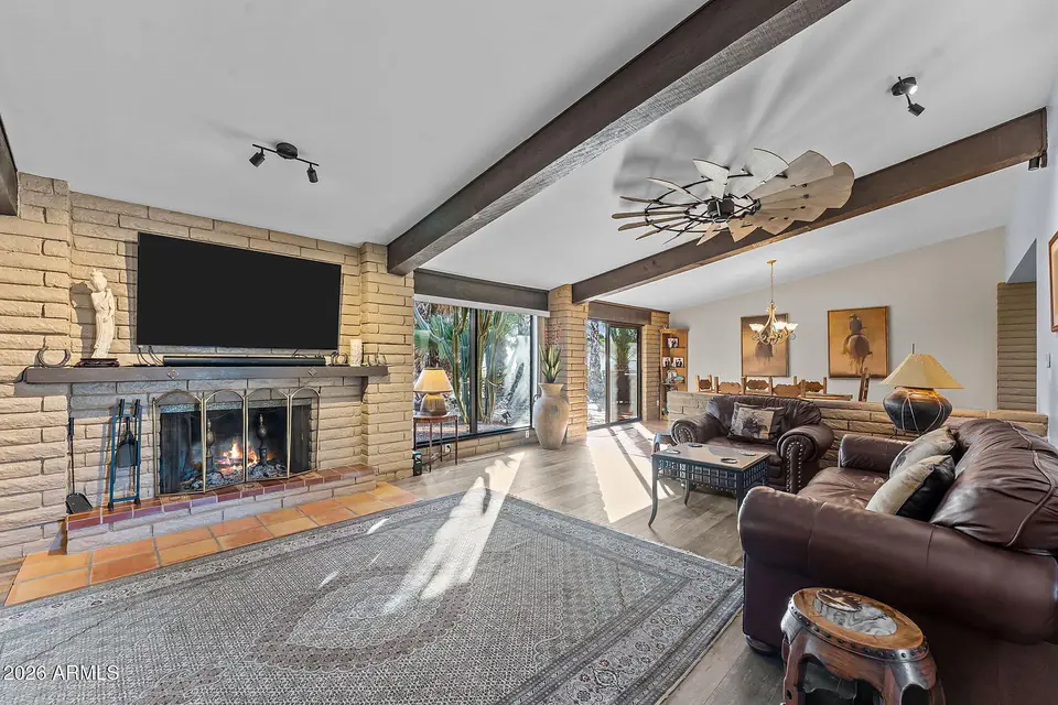 Great room with a slump-block fireplace, beamed ceiling, and view windows