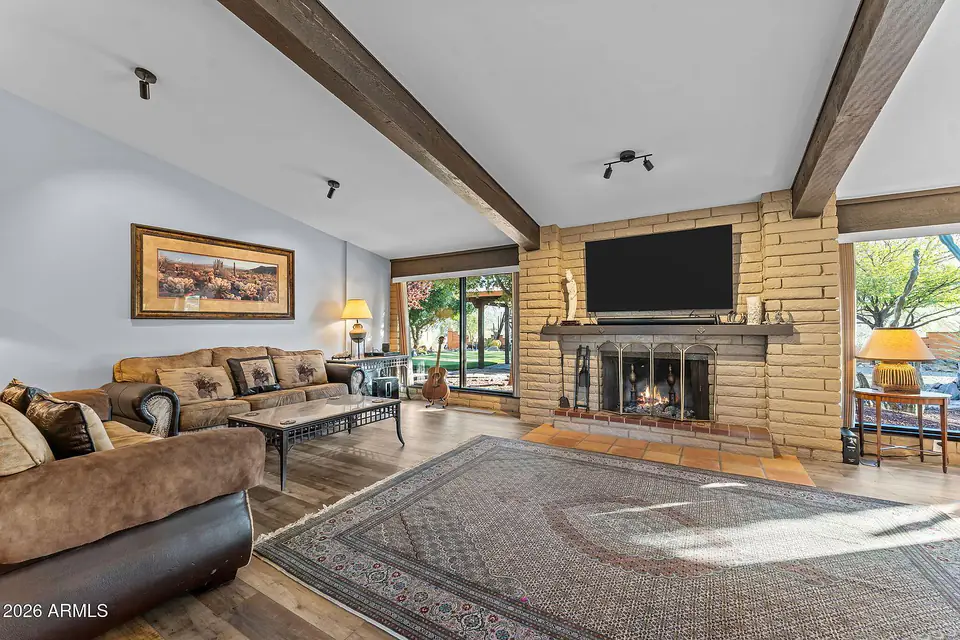 Great room with the wood-burning fireplace between picture windows