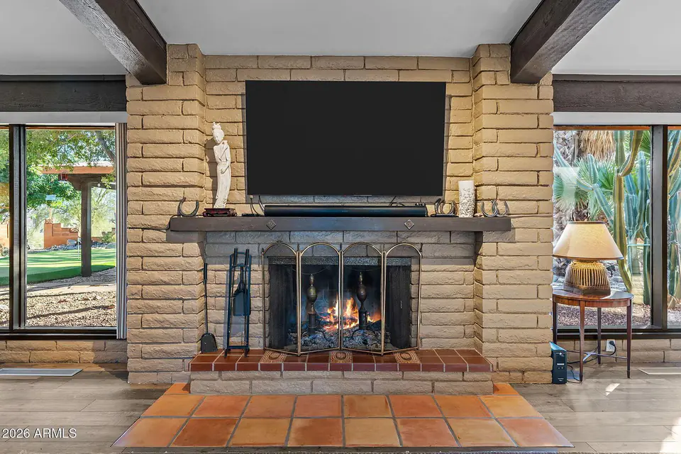 Wood-burning fireplace flanked by picture windows