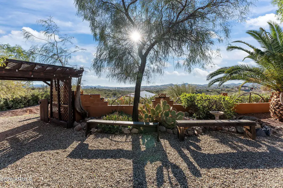 Gravel garden with pergola and benches overlooking the valley