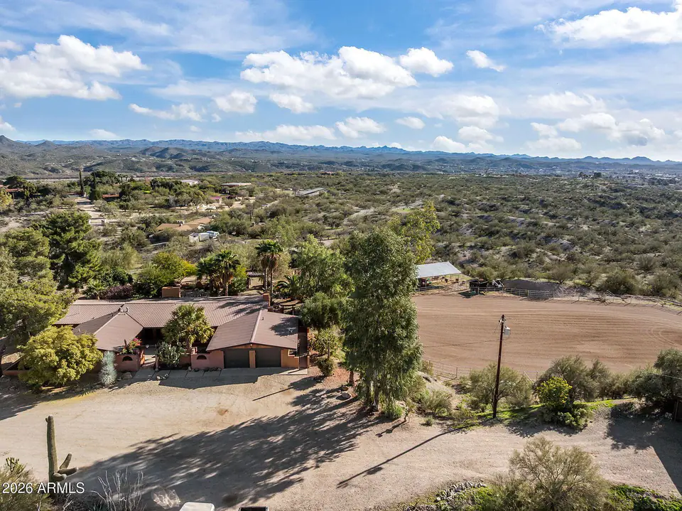 Aerial of the home beside the arena, mountains on the horizon