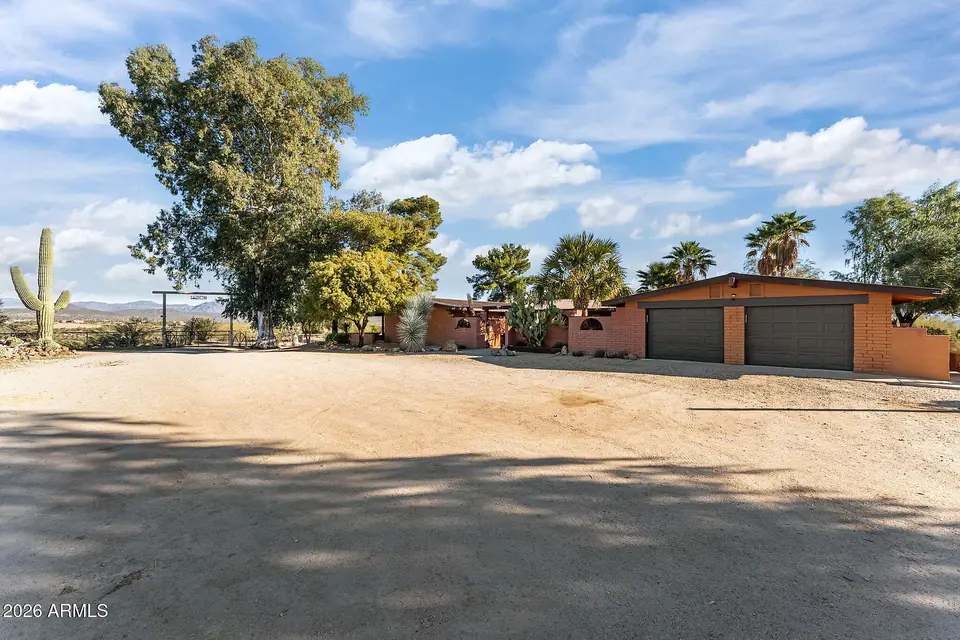 Front of the house with two-car garage, saguaro, and palms
